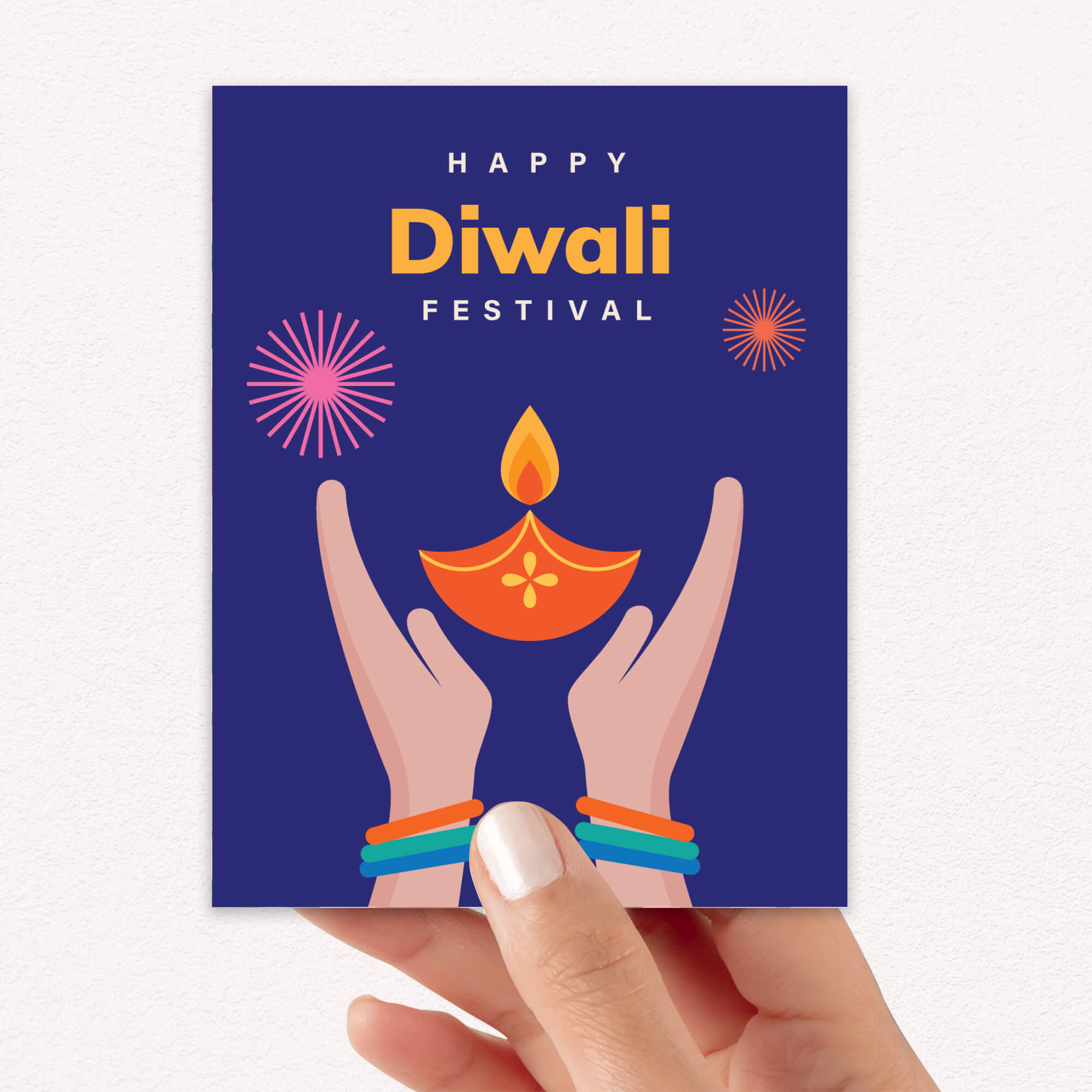 Hand holding a 'Happy Diwali Festival' card with hands holding a Diwali lamp.