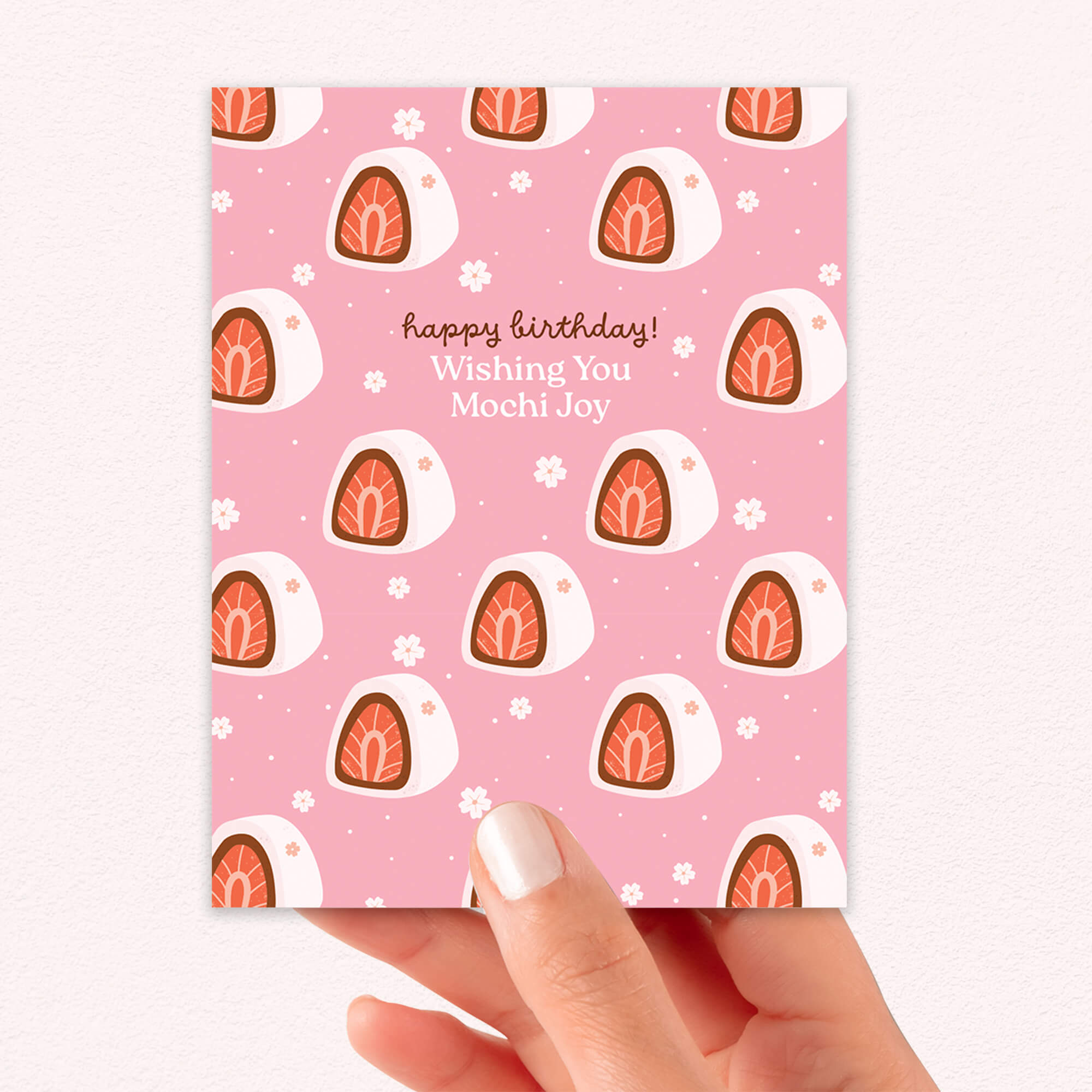 Pink birthday card with mochi design held by a hand