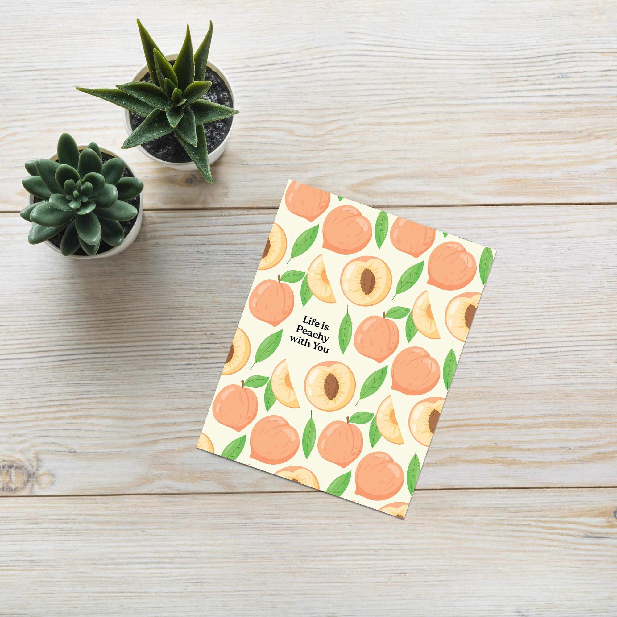 asian greeting card with peach pattern and 'Life is Peachy with You' text on a wooden surface with succulents.