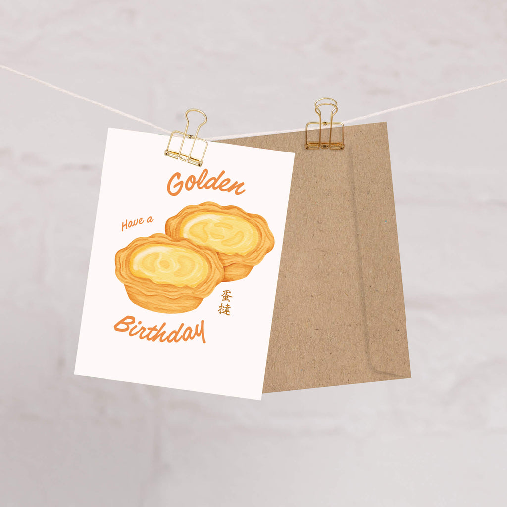 asian birthday Greeting card with two golden egg tart pastries and 'Have a Golden Birthday' text on a white background.
