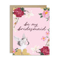 Greeting card with floral design and crane illustration on a pink background, featuring the text 'be my bridesmaid'.
