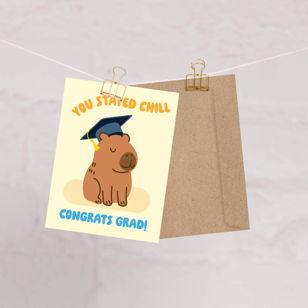 cute Graduation card with a capybara wearing a cap and 'You Stayed Chill Congrats Grad!' text on a yellow background.