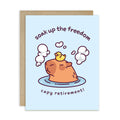 Greeting card with a cartoon capybara in a bath and text 'soak up the freedom capy retirement!' on a light blue background.
