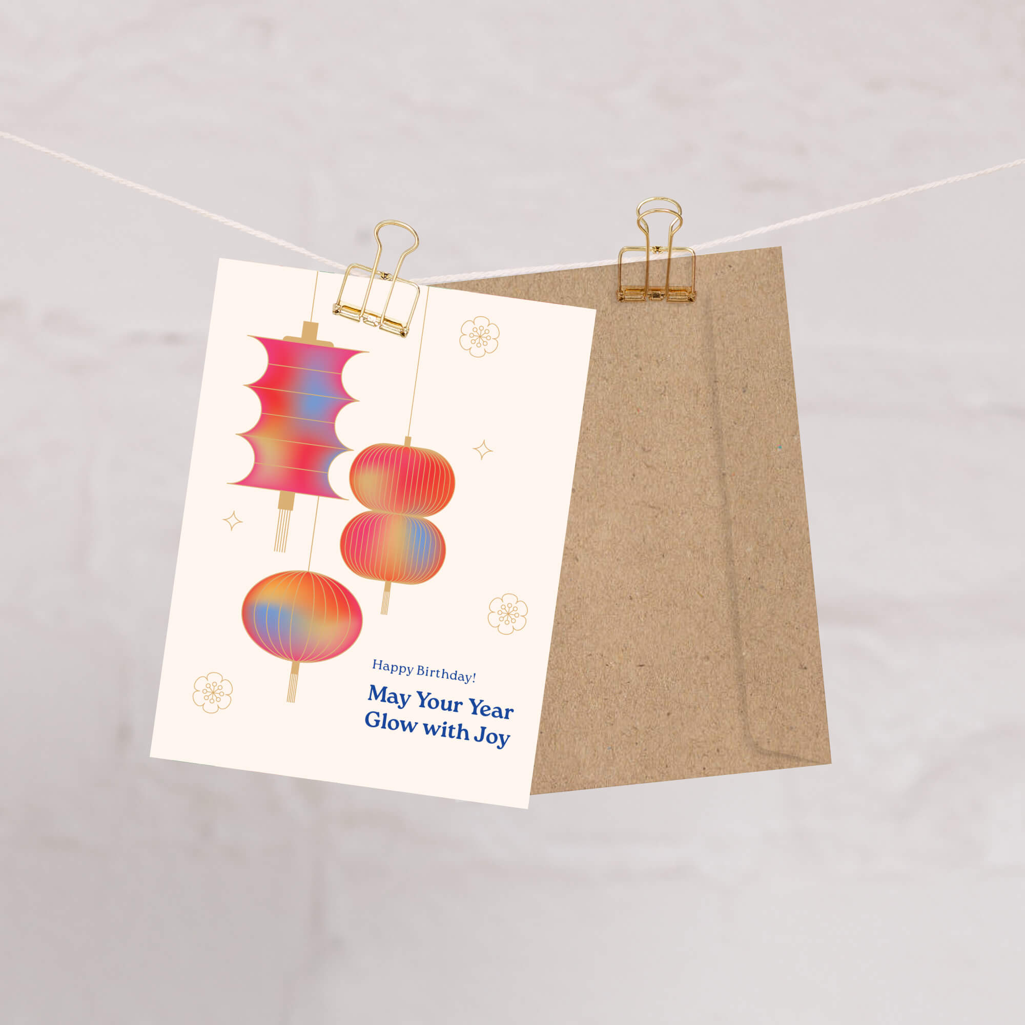 birthday card with colorful lantern design and kraft envelope on a white background
