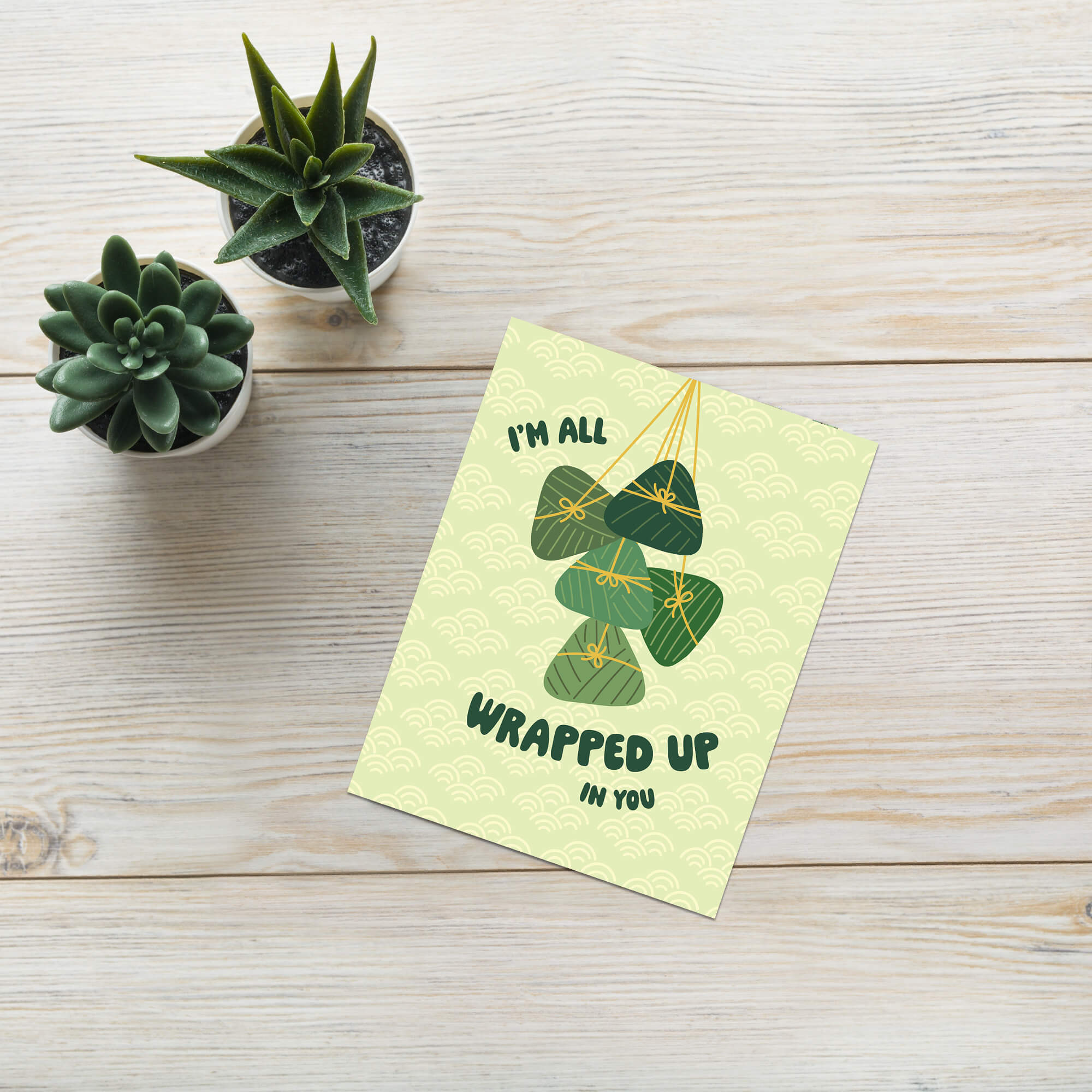 Greeting card with green banana leaf zong zi chinese tamale illustrations and text on a light green background dragon boat festival