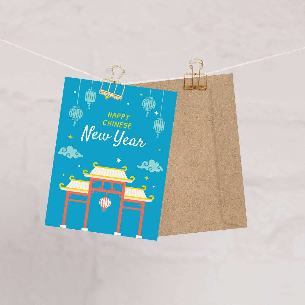Greeting card with 'Happy Chinese New Year' text and traditional gate design, hanging on a string.