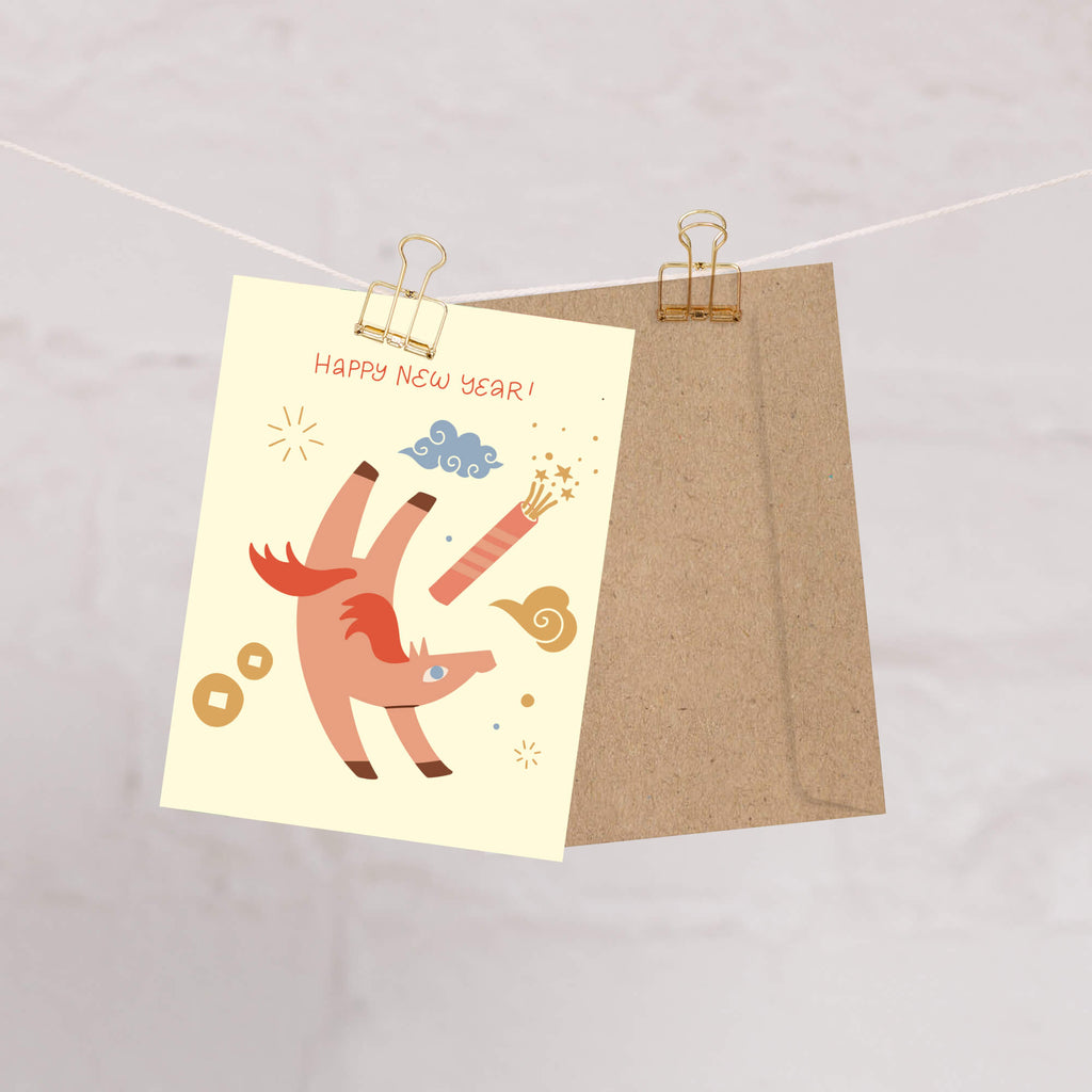 Happy chinese New Year card with a cartoon horse  design on a beige background, clipped to a string.