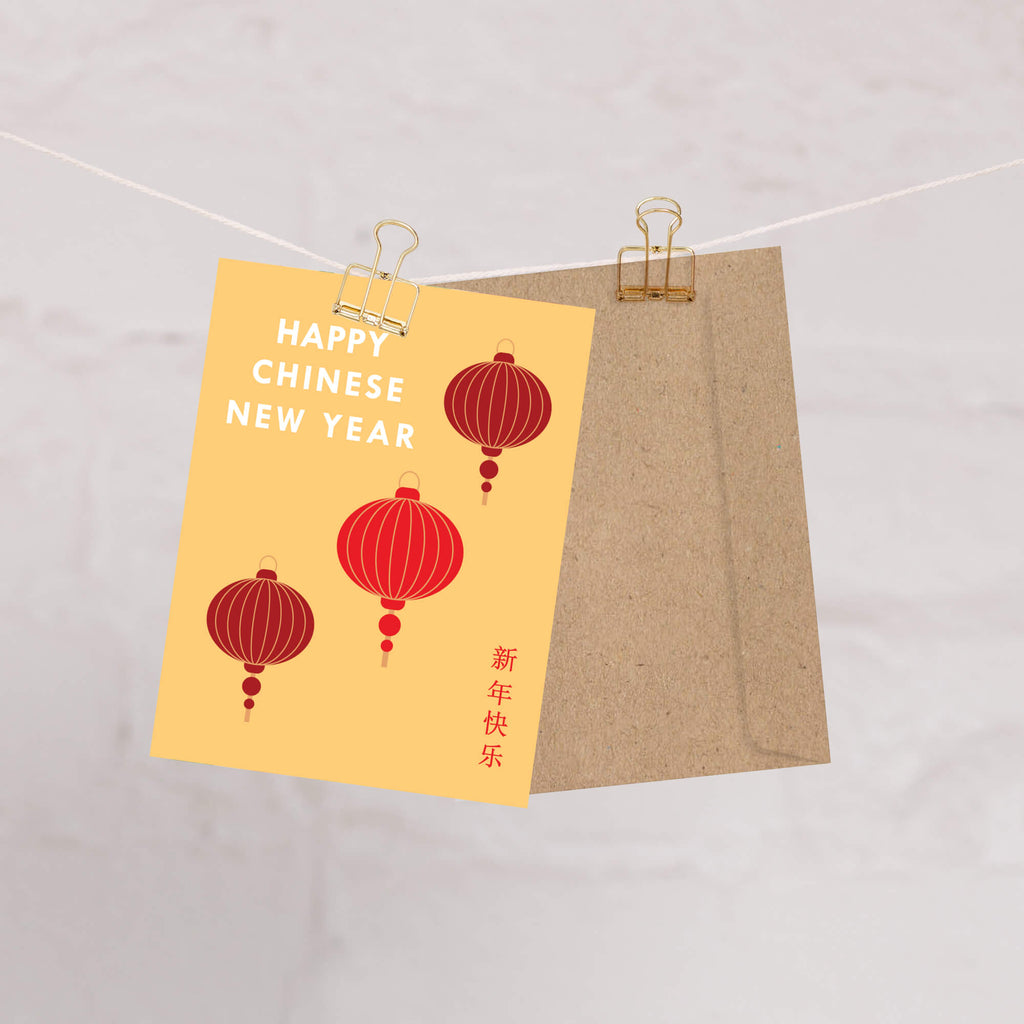 Card with red lanterns and 'Happy Chinese New Year' text, hanging on a string.