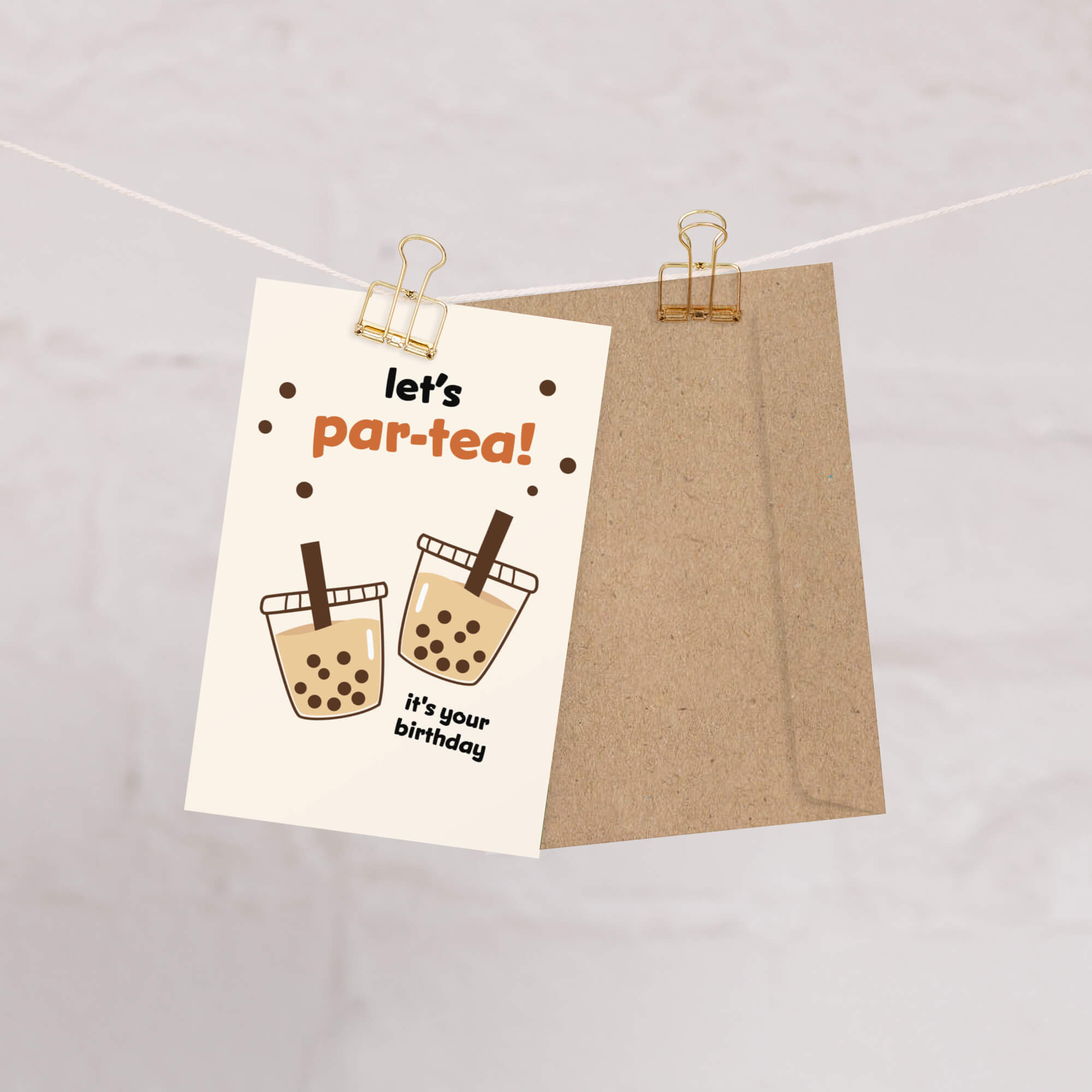 Card with 'let's par-tea! It's your birthday' text and illustrations of bubble tea, clipped to a string.