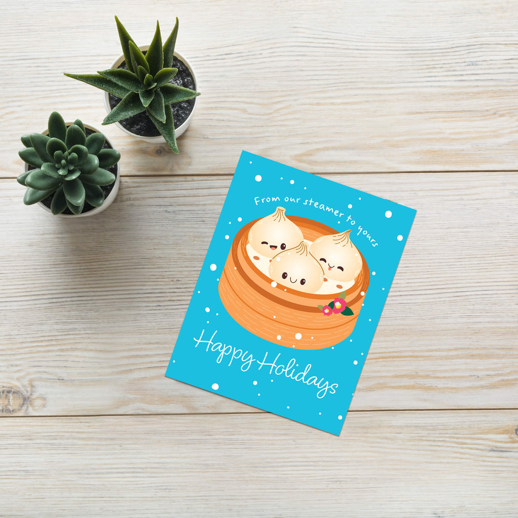 cute christmas greeting card with Three cute soup dumplings in bamboo steamer on teal snow with “From our steamer to yours. Happy Holidays.”