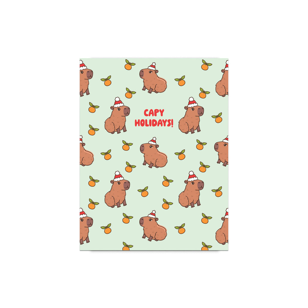 cute christmas card with Repeating pattern of capybaras in Santa hats with small oranges on a pale green background. Text reads a pun: “Capy Holidays.”