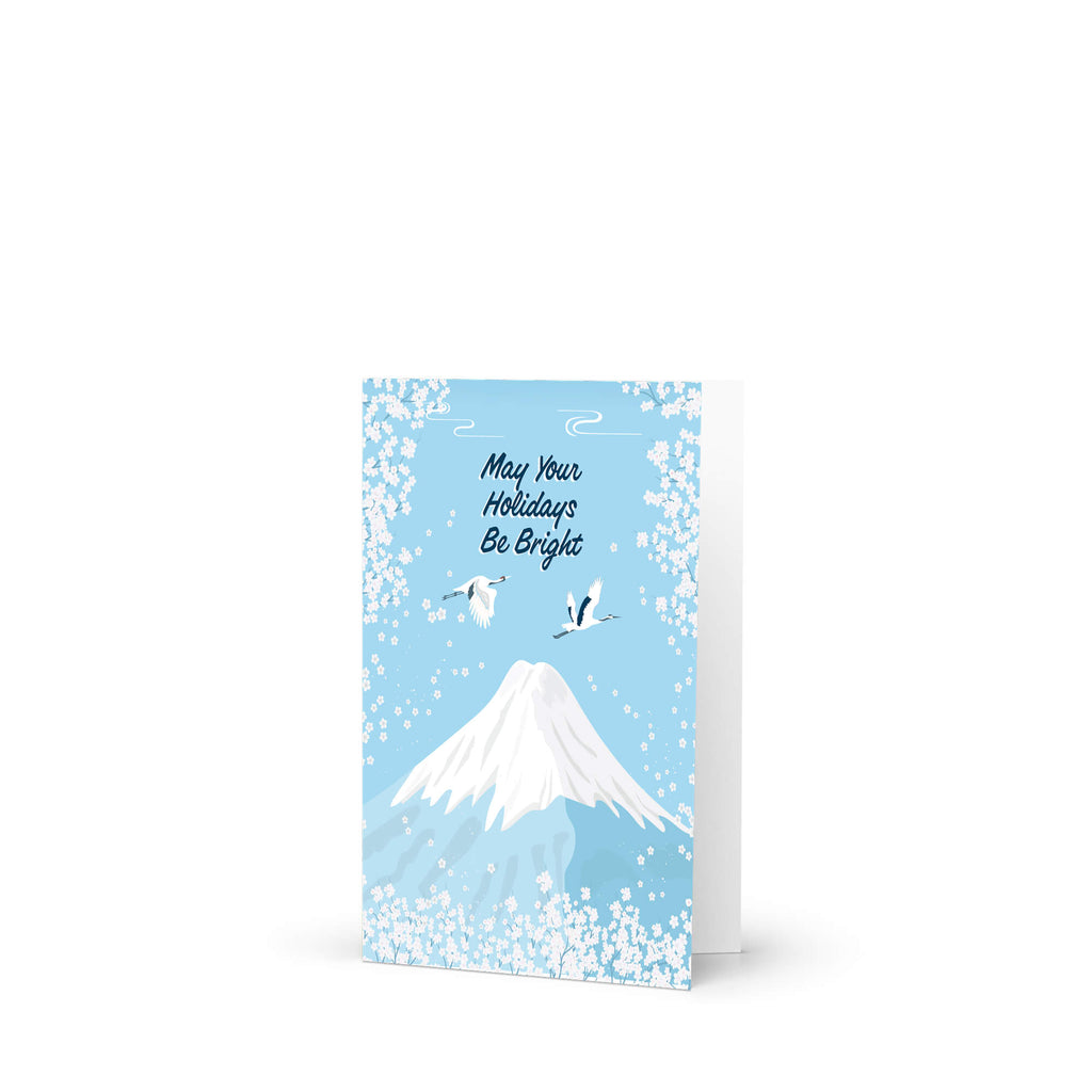 japanese christmas card with a winter snowy Mount Fuji with cranes and white cherry blossoms; text “May Your Holidays Be Bright.”