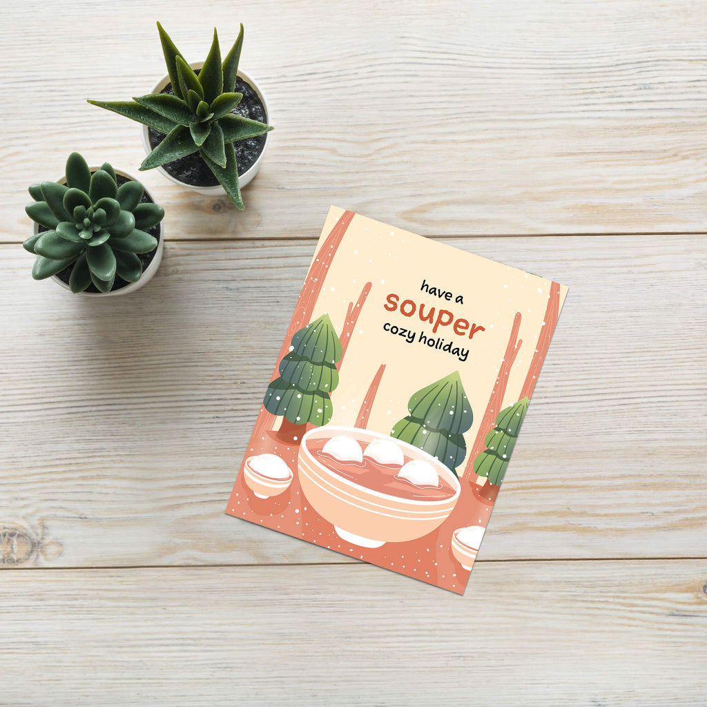 unique holiday Greeting card with a bowl of soup and winter scene, text 'have a souper cozy holiday'. 