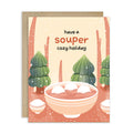 unique holiday Greeting card with a bowl of soup and winter scene, text 'have a souper cozy holiday'. 