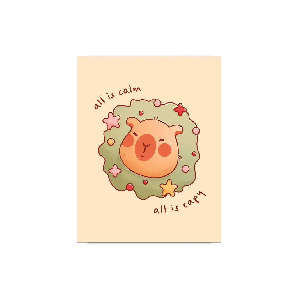 cute christmas card with a Capybara nestled in green holiday wreath with stars, text “all is calm, all is capy.”