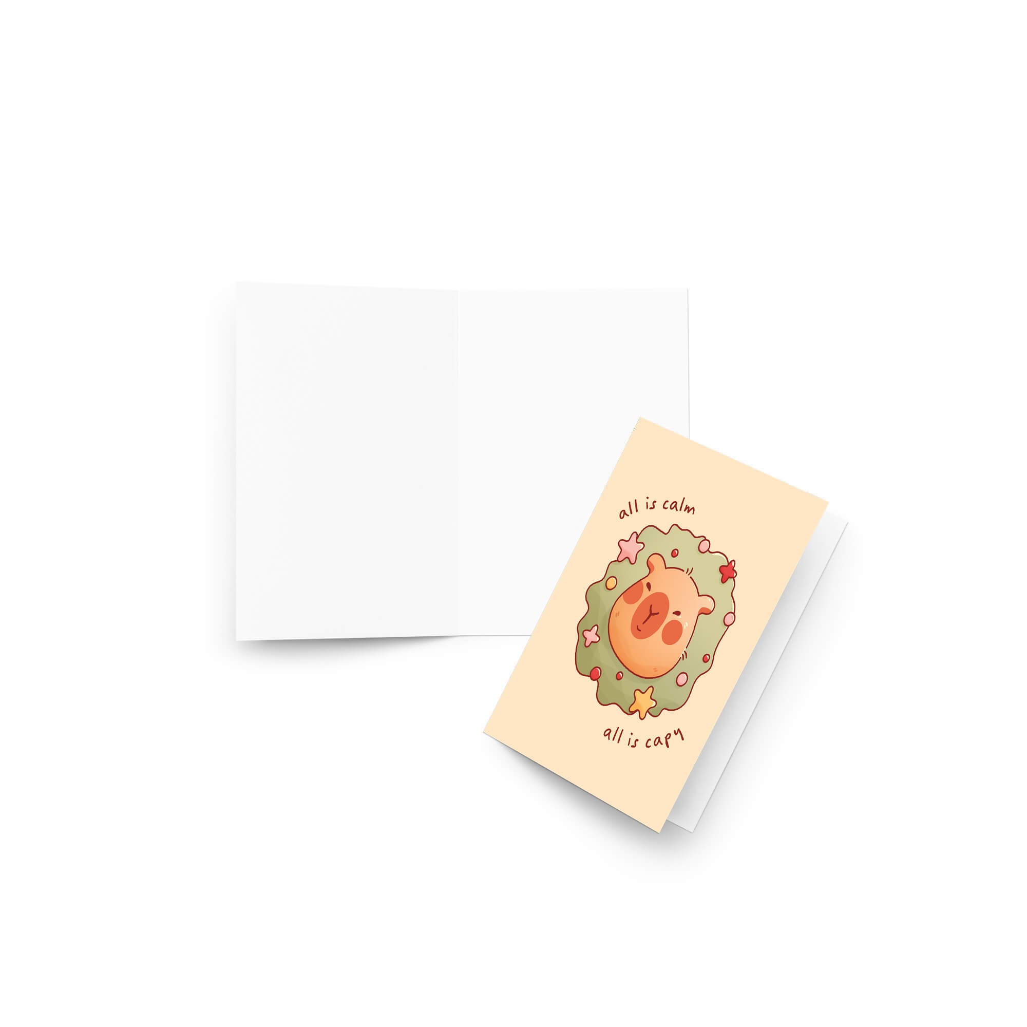 cute christmas card with a Capybara nestled in green holiday wreath with stars, text “all is calm, all is capy.”