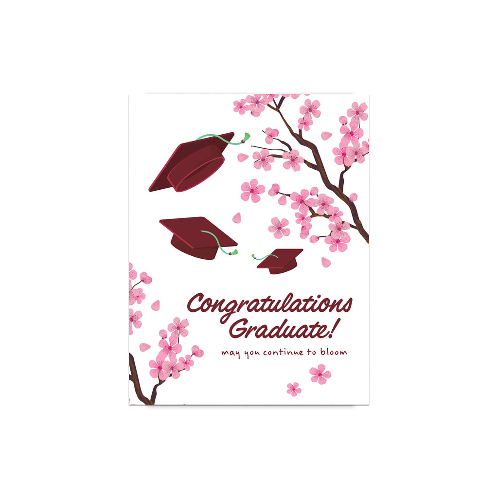 Graduation card with japanese cherry blossoms and red graduation caps on a white background
