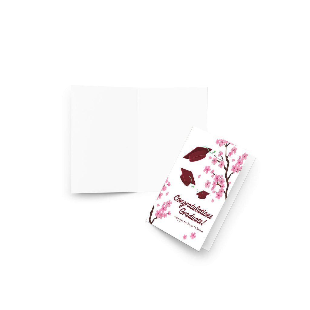 Graduation card with japanese cherry blossoms and red graduation caps on a white background