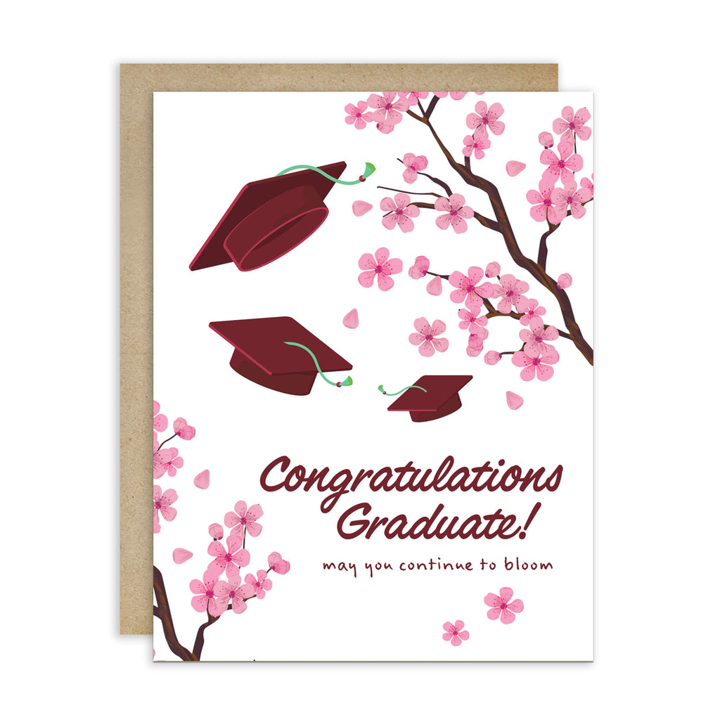 Graduation card with japanese cherry blossoms and red graduation caps on a white background