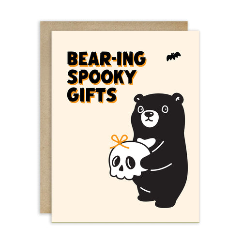 Halloween-themed greeting card with a bear holding a skull and text 'Bear-ing Spooky Gifts' on a beige background.