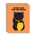 cute halloween Greeting card with a black cat holding a gold coin and 'No Bad Luck This Halloween' text on an orange background.