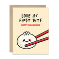 Greeting card with a cartoon dumpling with fangsholding chopsticks and text 'Love at First Bite Happy Halloween!' on a beige background.
