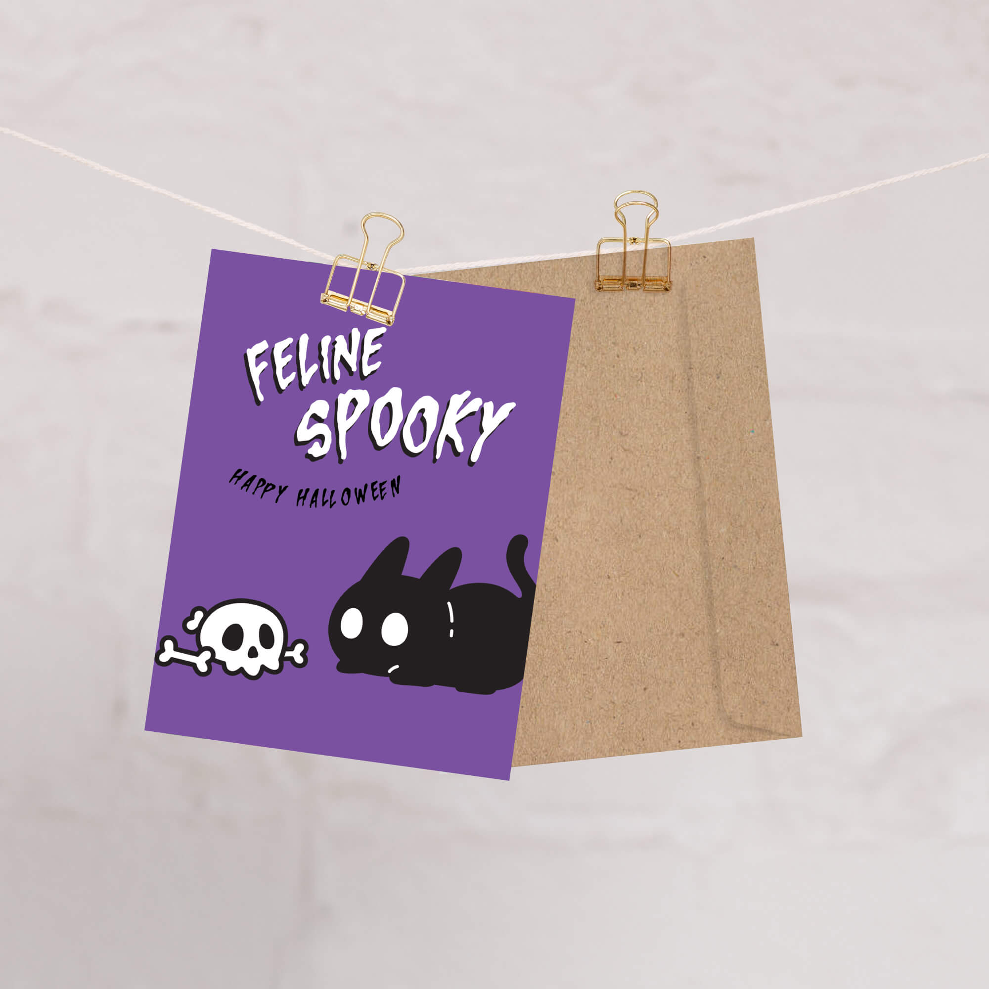 Halloween-themed card with a purple background and black cat illustration, hanging on a string.