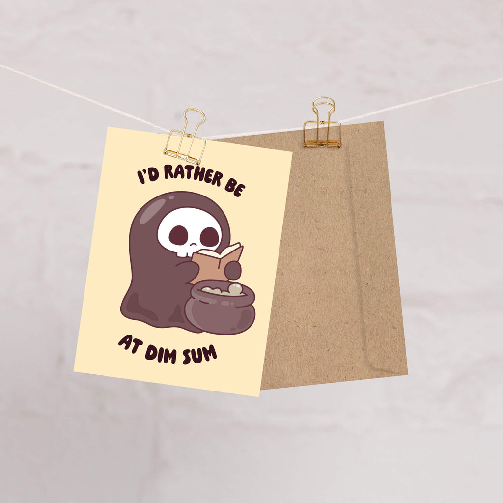 funny halloween Greeting card with a kawaii grim reaper holding a cauldron and text 'I'd rather be at dim sum' on a beige background.