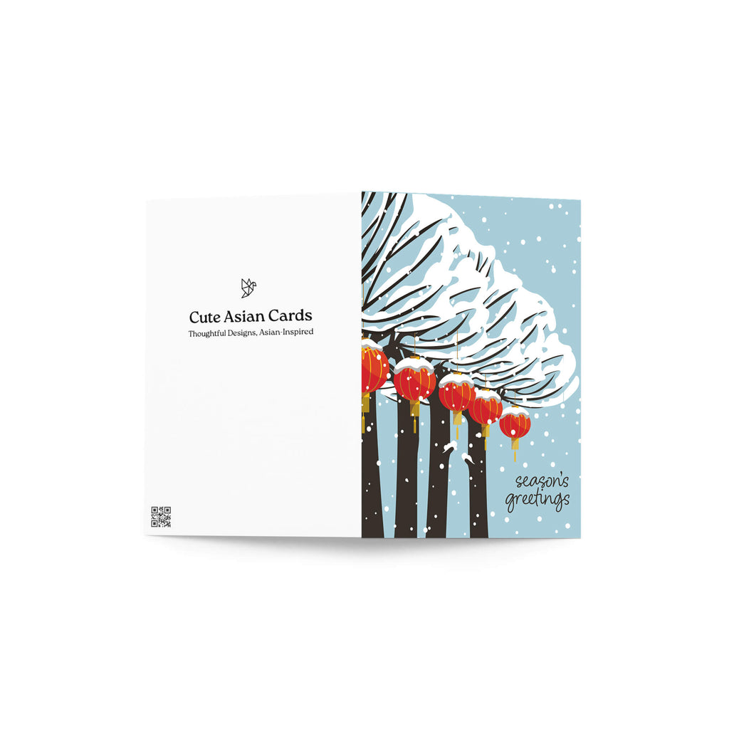 cute christmas card with Snowy trees with hanging asian chinese red lanterns and small “season’s greetings” text.