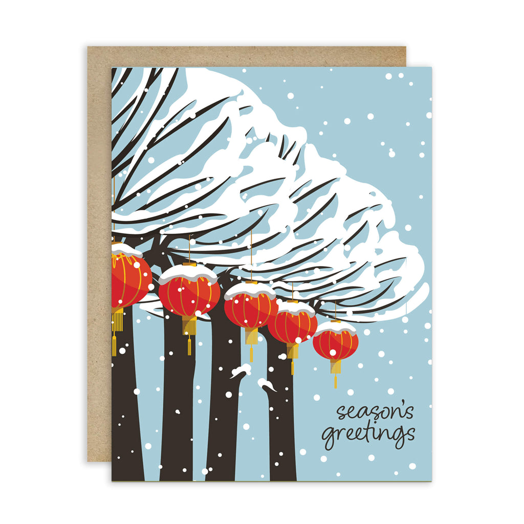 cute christmas card with Snowy trees with hanging asian chinese red lanterns and small “season’s greetings” text.