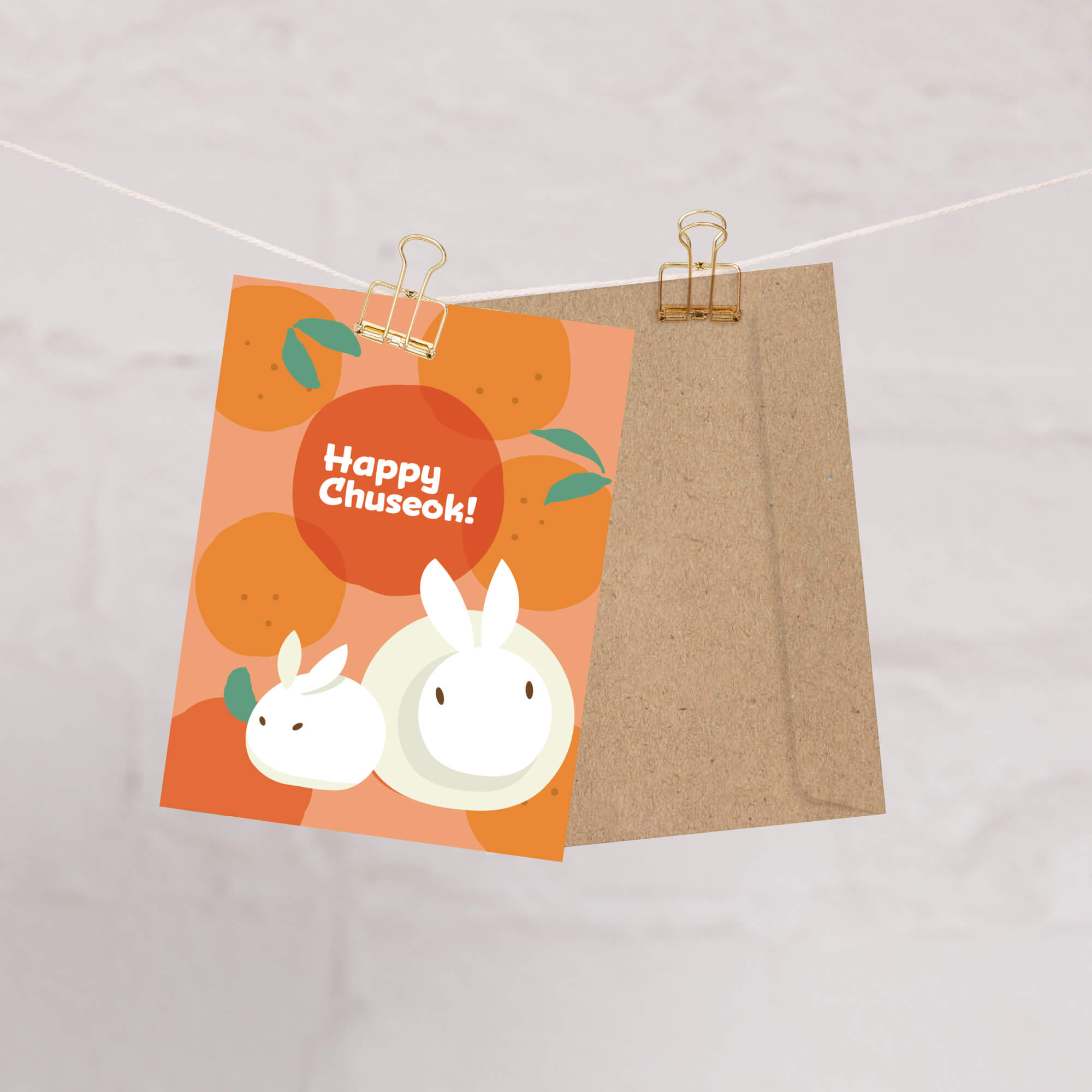 korean inspired Greeting card with rabbits designed as songpyeon and oranges on an orange background, featuring 'Happy Chuseok!' text.
