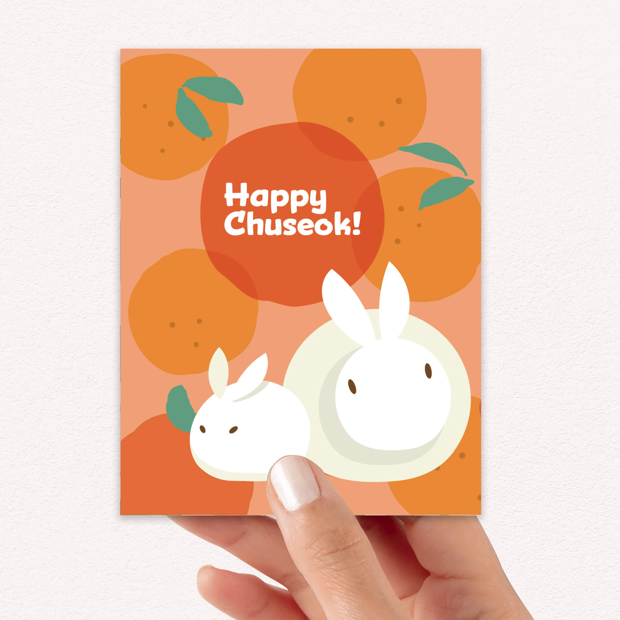 korean inspired Greeting card with rabbits designed as songpyeon and oranges on an orange background, featuring 'Happy Chuseok!' text.