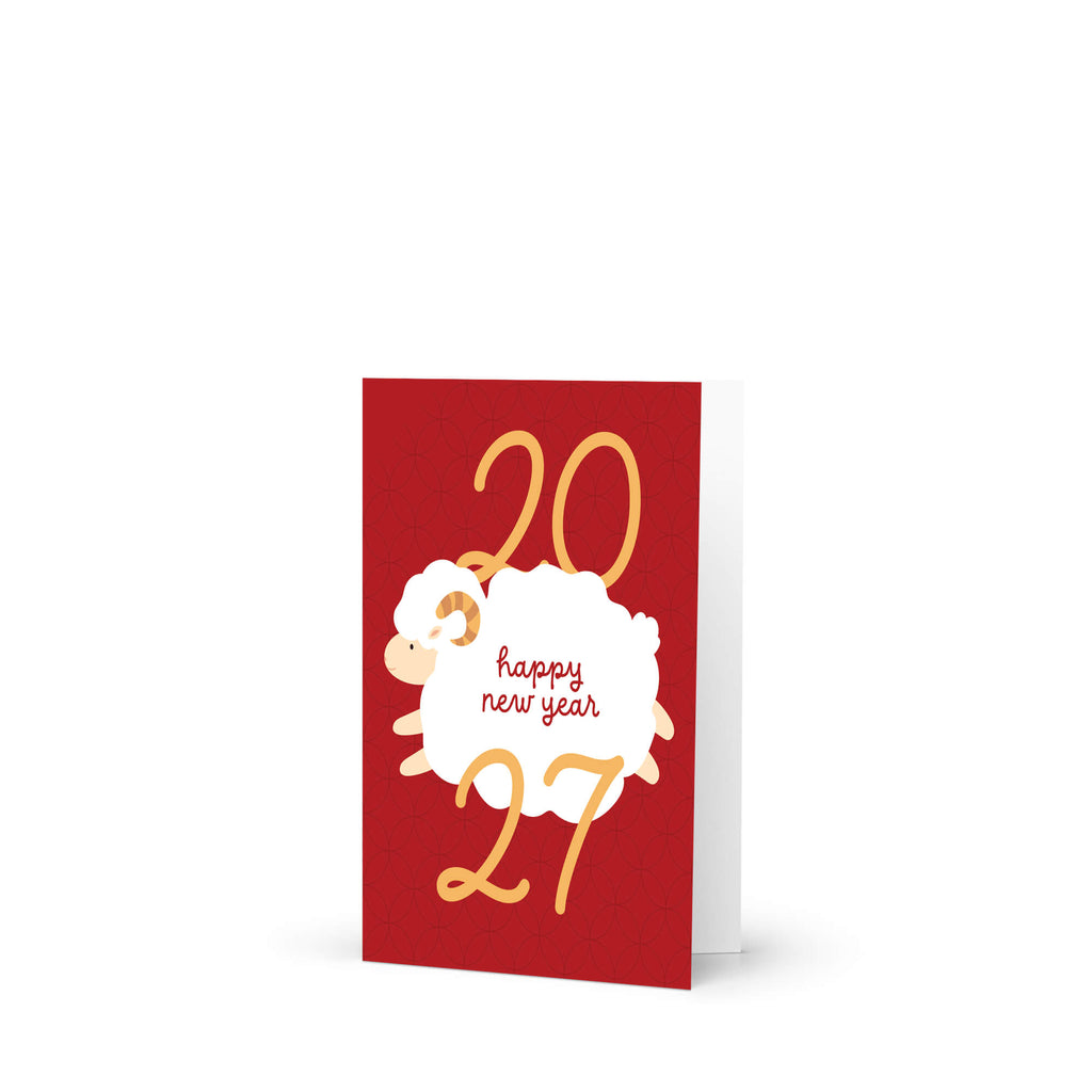 A red year of the goat card with a white sheep illustration and gold text reading '2027 happy new year', shown standing upright on a white background.