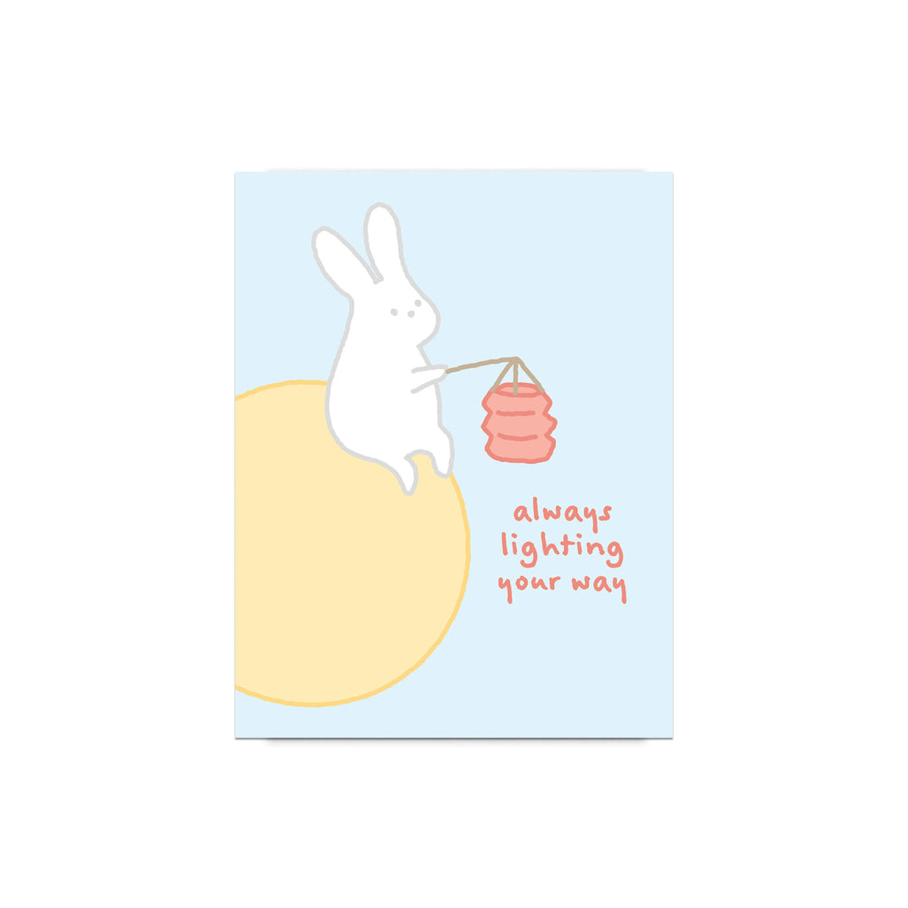 asian inspired Greeting card with a rabbit holding a lantern and text 'always lighting your way' on a light blue background. for mid autumn festival