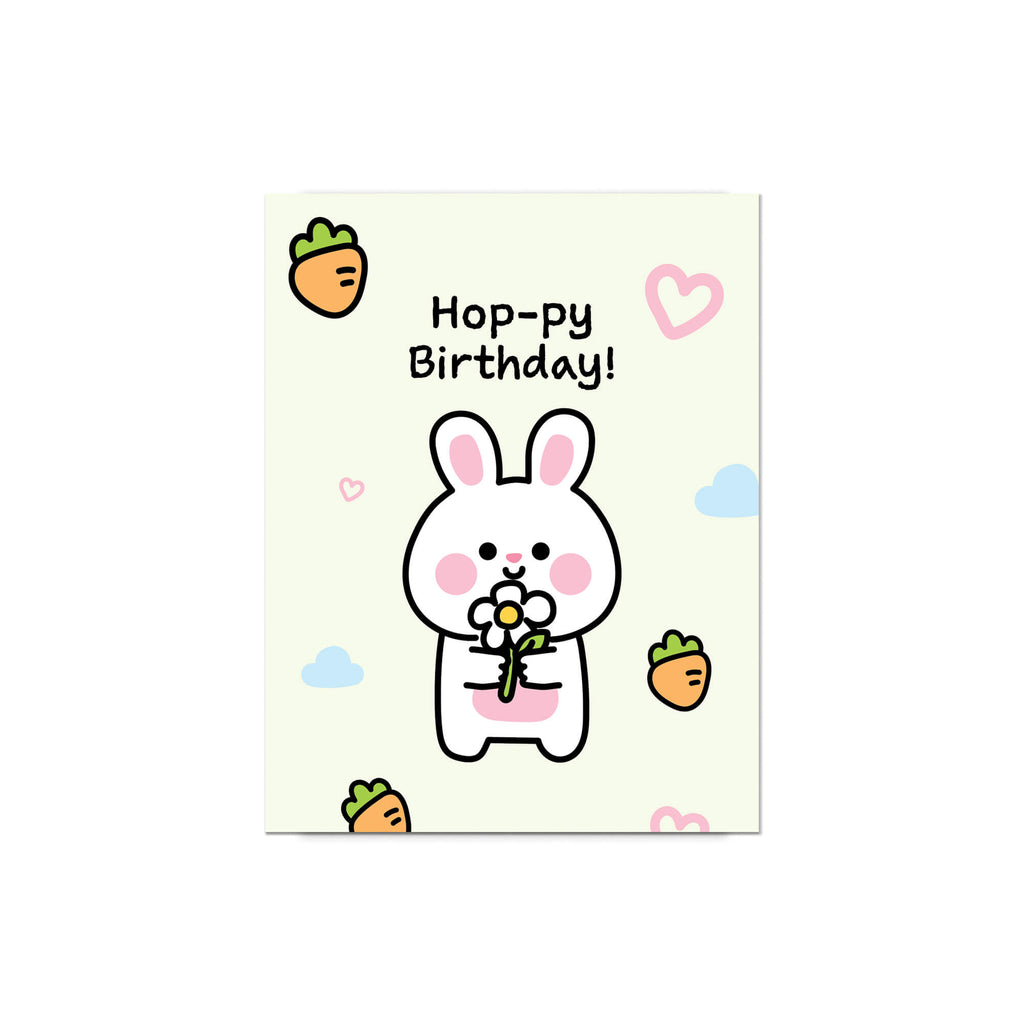 Birthday card with a cartoon rabbit holding a flower, surrounded by carrots and clouds on a light green background.