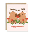 Valentine's Day card with cartoon capybaras and flowers on a white background