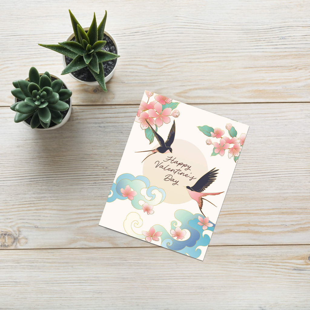 Two swallows flying near blossoms and pale sun with “Happy Valentine’s Day.”