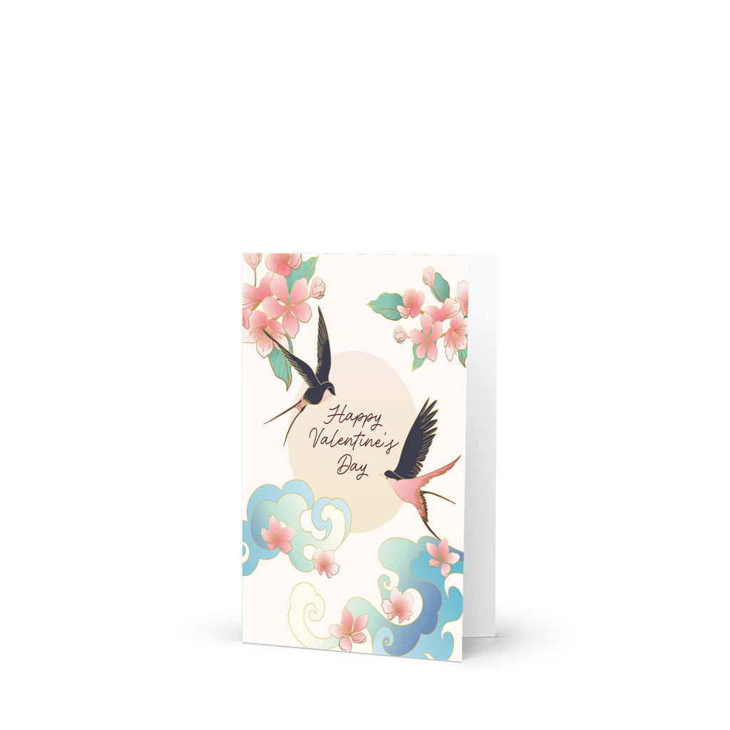 Two swallows flying near blossoms and pale sun with “Happy Valentine’s Day.”