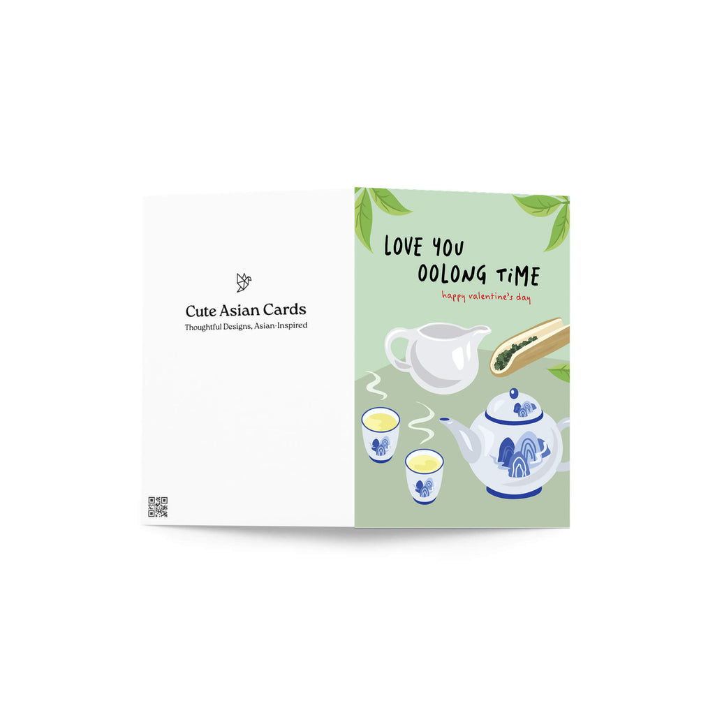 asian inspired valentintues day card with White and blue china teapot, cups, and oolong loose leaf tea on soft green; text “Love you oolong time.”