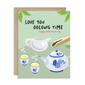 asian inspired valentintues day card with White and blue china teapot, cups, and oolong loose leaf tea on soft green; text “Love you oolong time.”