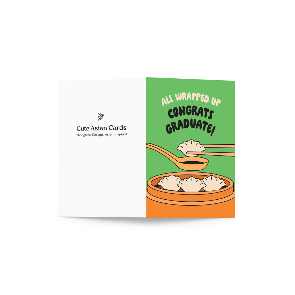 Graduation card with dumplings and text 'All Wrapped Up Congrats Graduate!' on a green background.