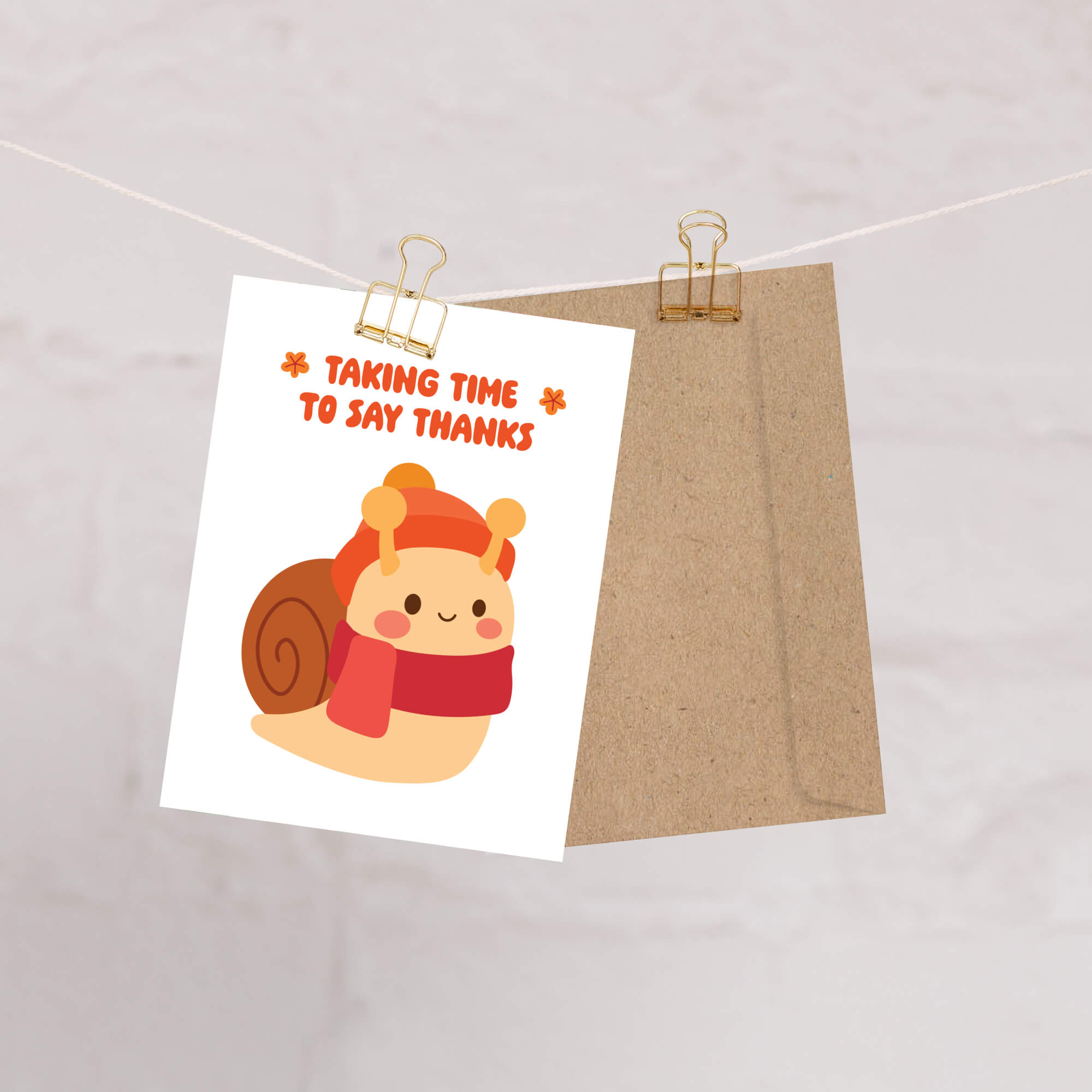 autumn Card with a snail wearing a hat and scarf, text 'Taking time to say thanks', and a brown envelope on a white background.