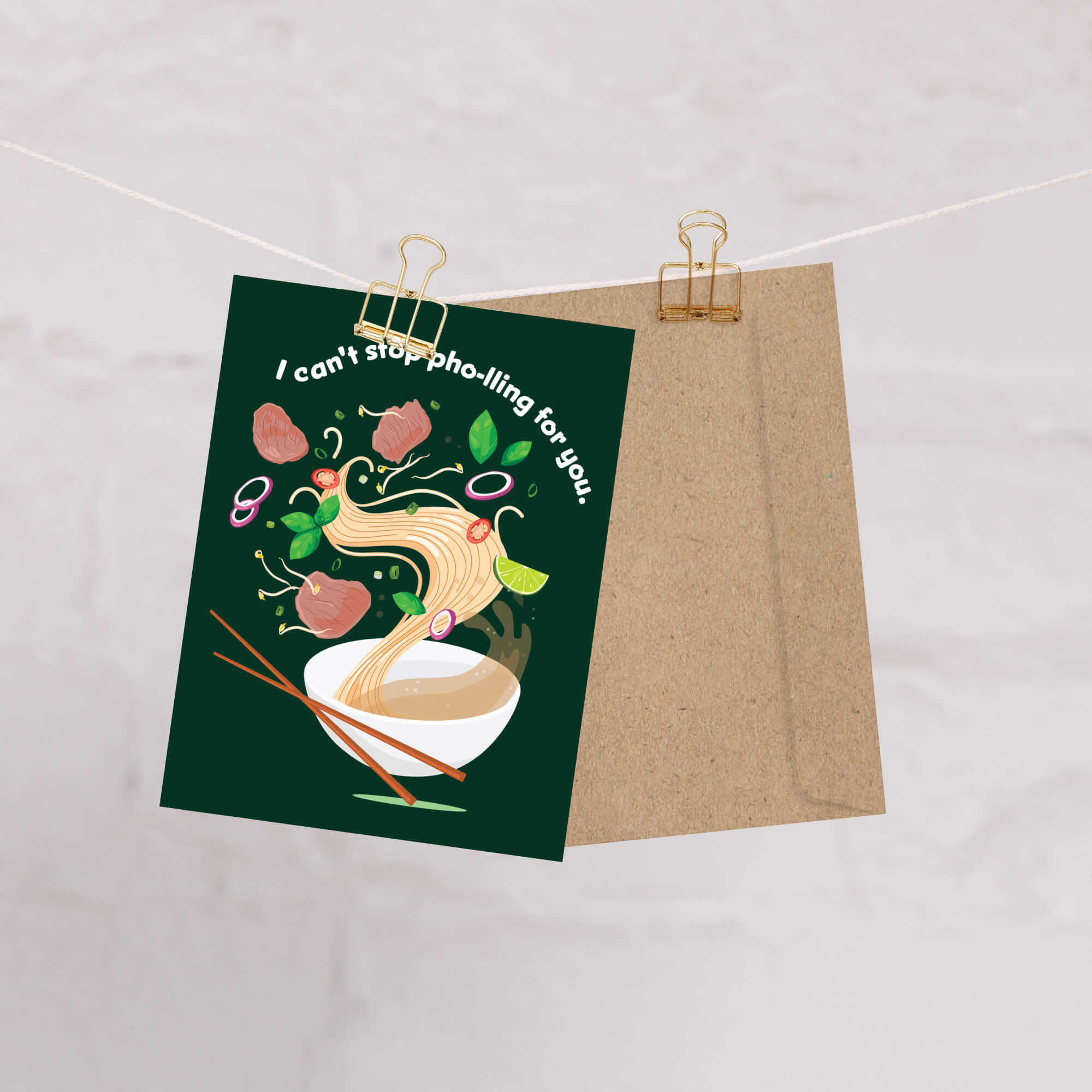 greting Card with pho illustration and text on a green background, clipped to a brown paper bag against a light background.