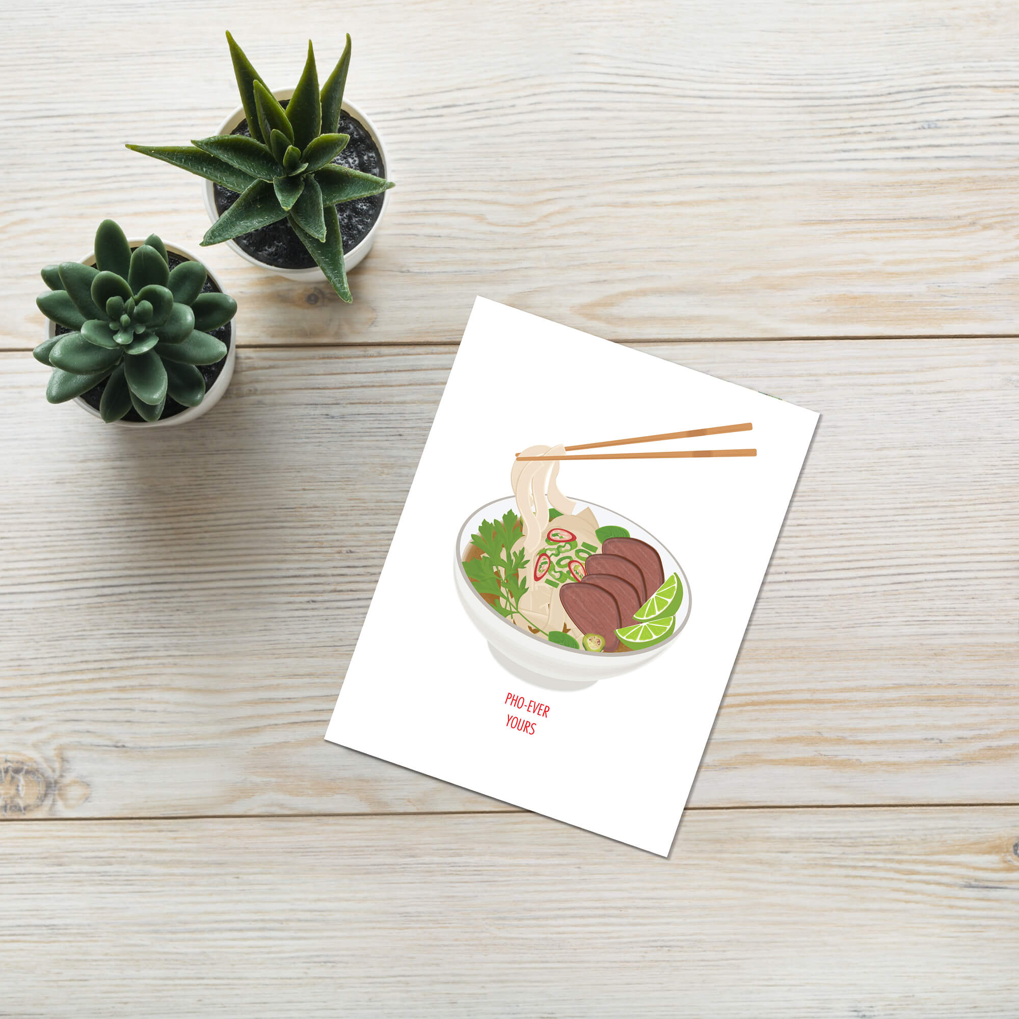 Card with a bowl of ramen illustration on a wooden surface with small potted plants.
