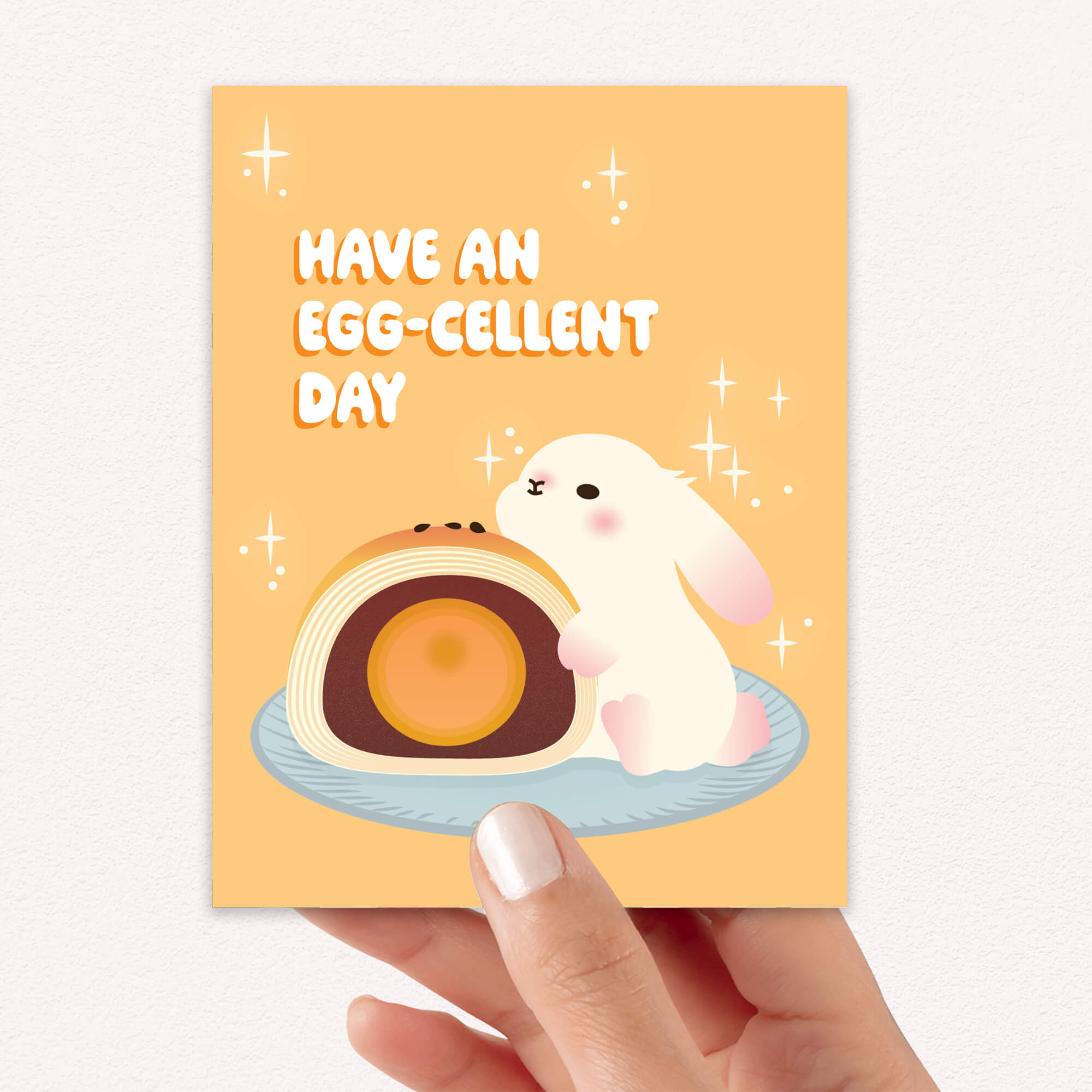 mid autumn festival Greeting card with a cute white bunny and egg yolk pastry, and text 'Have an EGG-cellent day' on a yellow background.