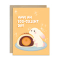 mid autumn festival Greeting card with a cute white bunny and egg yolk pastry, and text 'Have an EGG-cellent day' on a yellow background.