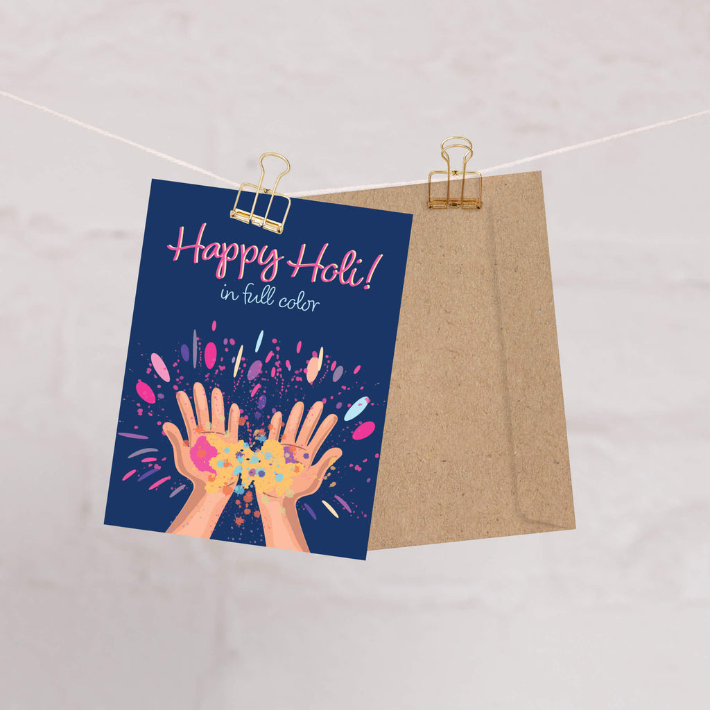 indian Greeting card with 'Happy Holi!' text and colorful hands holding gulal powder splashes on a blue background for the hindu festival of colors
