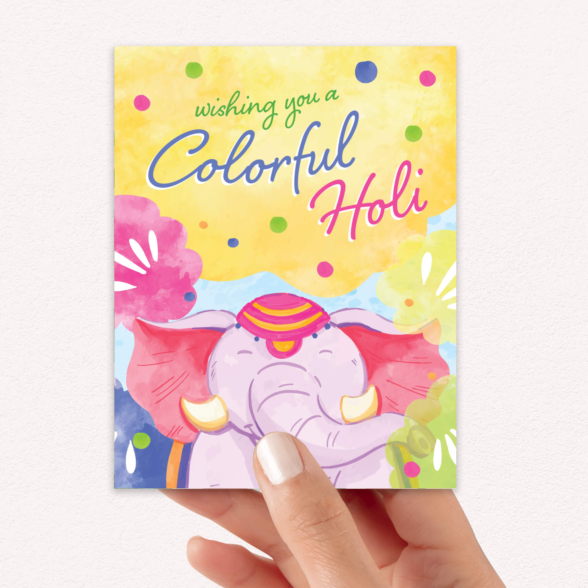 Colorful Holi card with an elephant design held by a hand on a white background