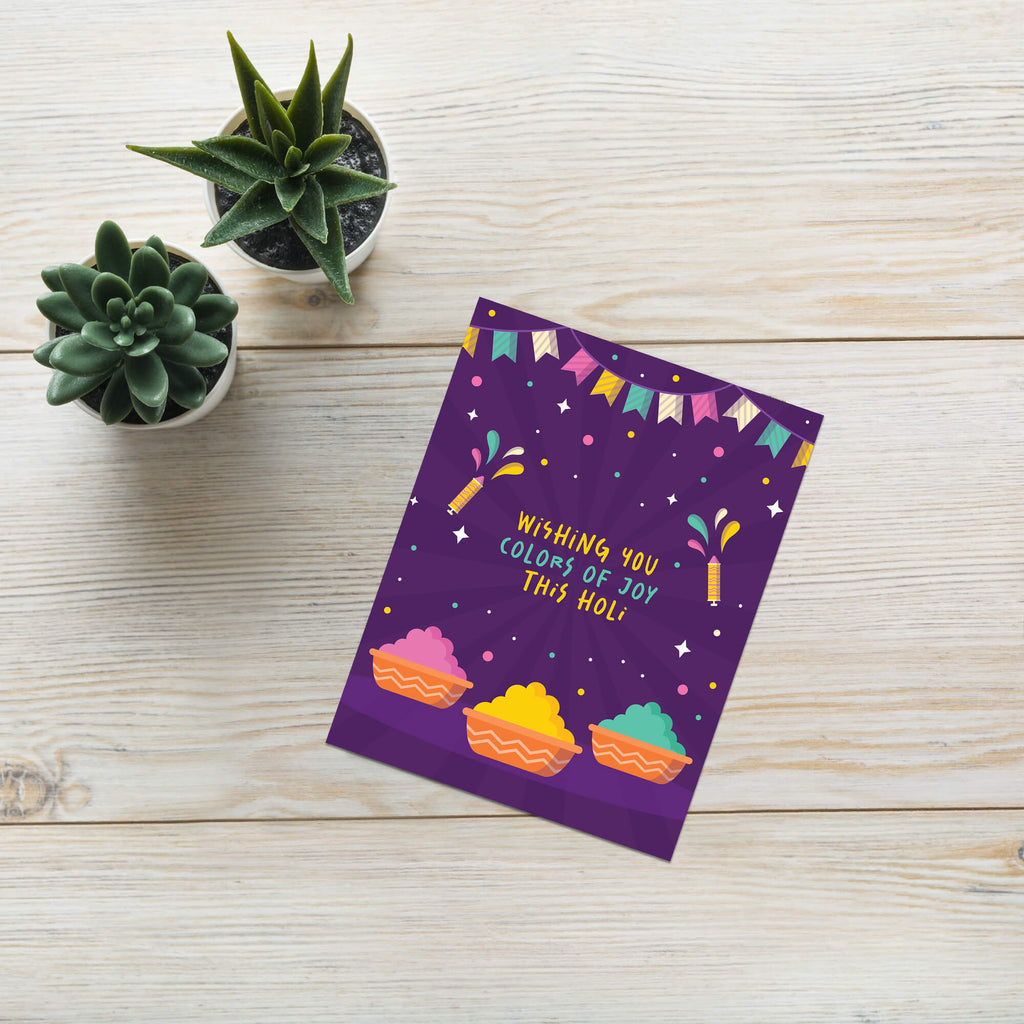 indian Greeting card with colorful design and text 'Wishing you colors of joy this Holi' on a purple background for hindu festival of colors