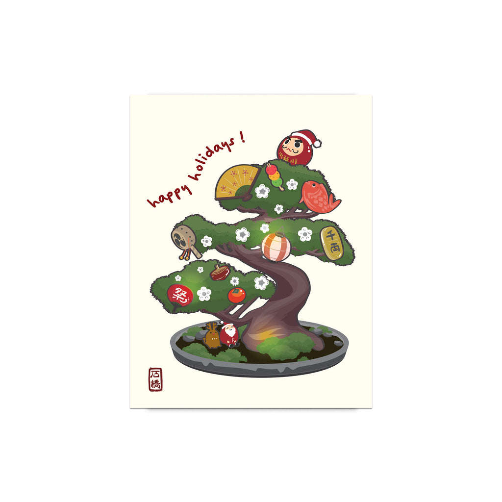 cute japanese christmas card with an Illustration of a bonsai tree decorated with lucky charms, daruma, and red lanterns. Text reads “happy holidays!”